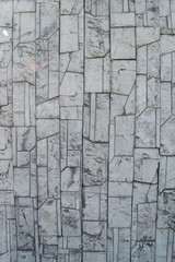 textured gray stone patterned tile laid out on a wall in the open air