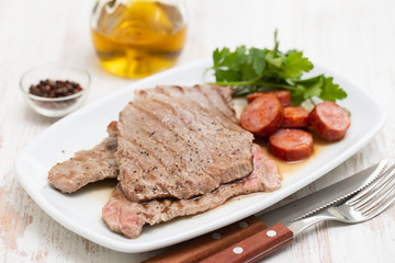 grilled meat with smoked sausage on white dish