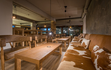 Big sofa decorated with cowhide pillows in modern restaurant