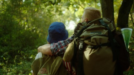 Young couple hugging during hiking in the forest with backpacks