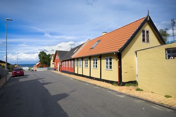 Fototapeta na wymiar Traditional colorful half-timbered houses in the street leading towards harbor in Hasle, Bornholm, Denmark