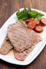 grilled meat with smoked sausage on white dish