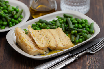 cod fish with green beans and peas on dish