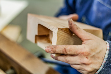 Eco friendly woodworker's shop. Details and focus on the texture of the materials, saw dust, and blocks, while making a designer coffee table with a drilling machine. Cnc woodery tools.
