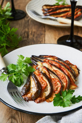 Baked eggplants with tomatoes, garlic and cheese on a plate