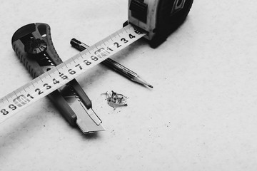 Table composition with roulette, pencil, cleric knife and shavings in grayscale. Monochrome...