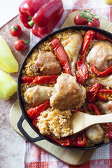 Chicken thighs and legs baked over a bed of rice and red bell pepper