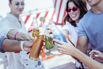 Refresh yourself. Pleased young people standing close to each other while enjoying their weekend