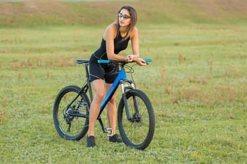 Girl on a mountain bike on offroad, beautiful portrait of a cyclist at sunset