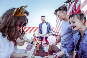 Prepare place. Joyful brunette man expressing positivity while bringing pizza