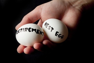 Hand Holding Two Eggs Marked Retirement And Nest Egg