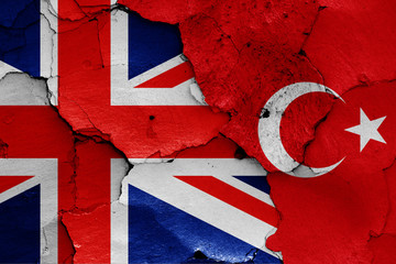 flags of UK and Turkey painted on cracked wall