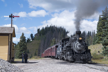 Cumbres Toltec historic narrow-gauge steam train engine stopped at Cumbre Pass on the way to...