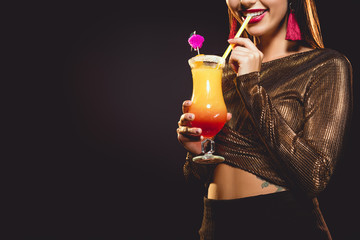 cropped view of happy girl drinking sweet cocktail on black