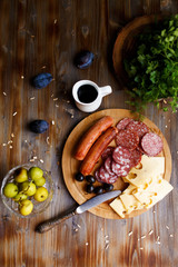 Overhead view of aperitif table Meat snack, fried sausages, cheese, salami, olives and a glass of...