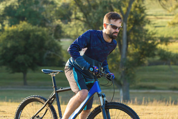 A cyclist rides the hills, Beautiful portrait of a guy on a blue bicycle	