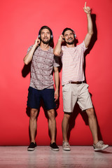 Fototapeta premium Full length portrait of a two young cheerful twin brothers