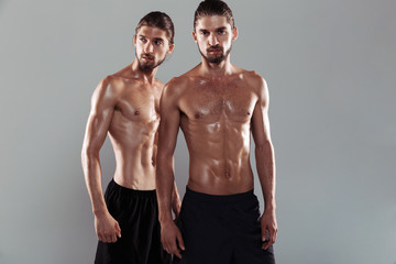 Fototapeta na wymiar Portrait of a two confident muscular shirtless twin brothers