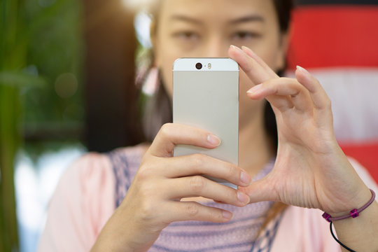 Focus hand of Young asian woman take photos with smartphone.