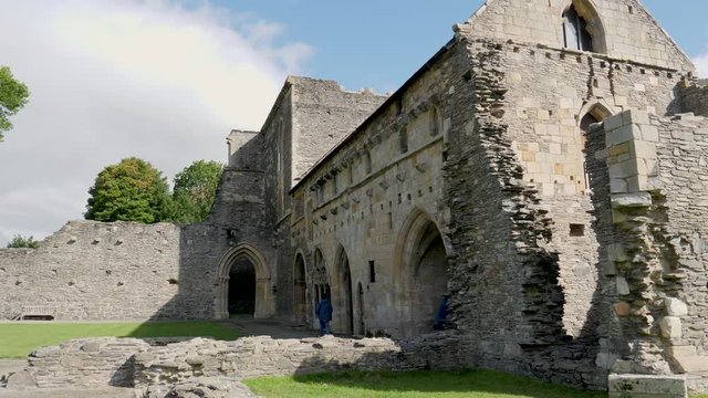 Unidentifiable tourist takes cell phone photo at the ruins of the Valle Crucis Abbey in Denbighshire, Wales