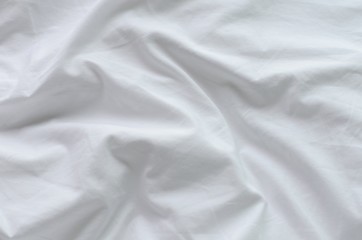 Top view of messy white color bed sheet texture background.