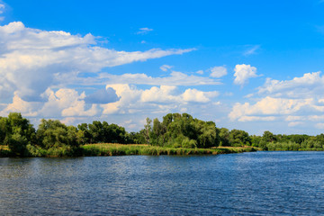 Fototapeta na wymiar Summer landscape with beautiful lake, green trees and blue sky