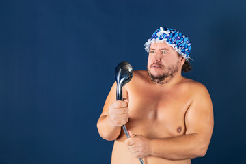 Funny fat man in blue cap sing in the shower