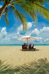 Fototapeta na wymiar couple sitting and relaxing tropical the beach
