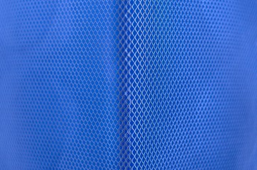 Blue color paper with partial focus of the grid pattern of paper bin that design as modern background and wallpaper.