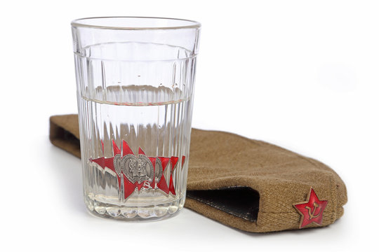 Glass with vodka and medal of red star and forage-cap isolated on white