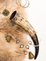 Obraz premium Curved horn of the Vikings and ancient decorations on rifles the coat and a white background