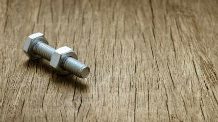 Naklejka premium nuts and bolts on abandoned wood desk.