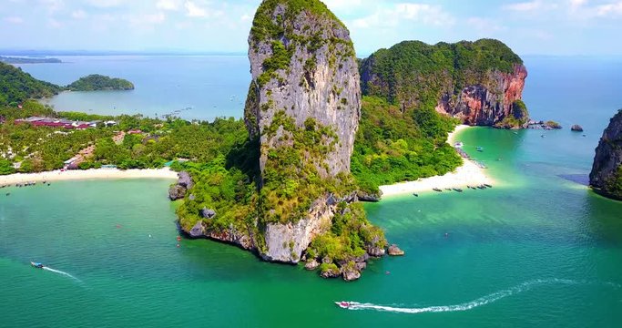 Boats Navigating Around Dramatic Rock Island in Tropical Bay with Beach and Multiple Islands in Background - Phra Nang Bay, Thailand