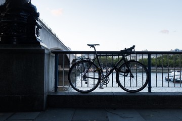 Bicycle tied to a railing by the Thames river