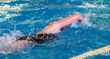 Sports background for splash topics - Sport swimming in the pool. Unsharp background on sports theme of a healthy lifestyle - swimming in the pool