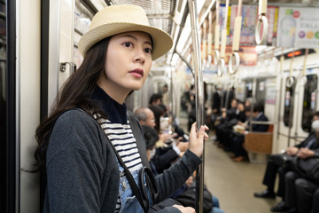 a female traveler wearing a straw hat taking MRT