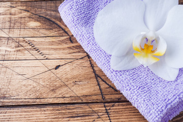 Obraz na płótnie Canvas Spa and Wellness concept on wooden background. Colorful Terry towels and a white Orchid flower.