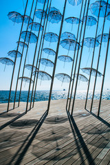 The seafront in the city of Thessaloniki, Greece. Mediterranean Sea,performance on the beach with umbrellas - obrazy, fototapety, plakaty