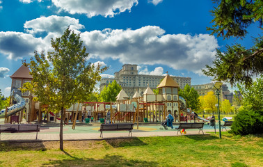 Playgroud for Kids in Izvor park and famous Parliament building landmark in Bucharest, Romania