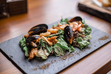 Seafood salad. Warm salad with leaves, shrimp, mussels and sause.