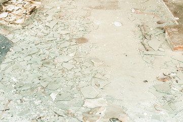 Big pile of broken and shattered window glass on the floor of the house demolished after earthquake...