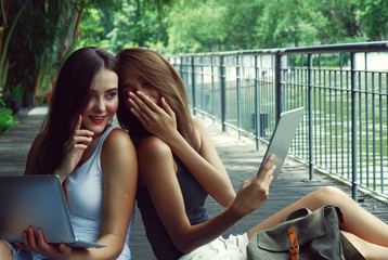 Beautiful two women gossip talking and relaxation in park.