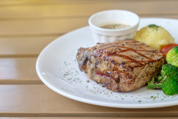 Juicy grilled pork steak with Broccoli tomato and mash potato in White plate