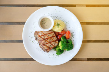 Top view of delicious grilled pork steak with Broccoli tomato and mash potato in White plate