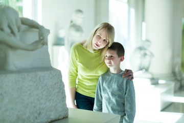 Mother and son regarding classical bas-reliefs