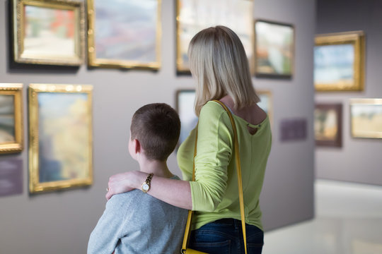 Positive mother and son exploring paintings