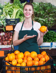 Saleswoman holding oranges in market