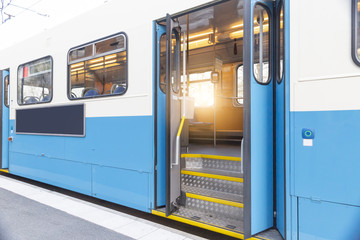 Tram stop on tramway, door opened, big empty advertising board with copy space, public transportation in modern 