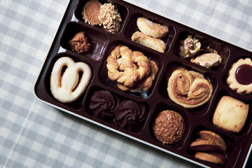 Variety of cookies are placed in the plastic tray, and put on the cloth ( napkin ) with a beautiful pattern.