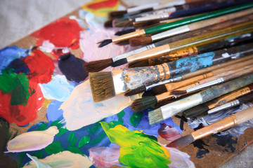Fototapeta premium Multicolored palette and many different brushes.